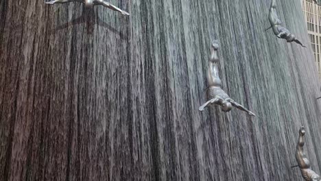 Jumping-Divers-Sculptures-and-Artificial-Waterfall-in-Dubai-Mall,-UAE