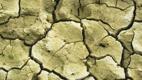 Looking-down-across-arid-cracked-sandy-barren-yellow-dehydrated-ground