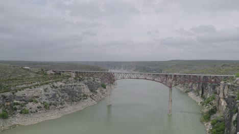 Bridge-over-the-Pecos-River-in-West-Texas,-traffic-passing-by