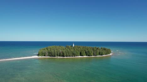 Drohnen-Luftaufnahme-Einer-Kleinen-Insel-Mit-Leuchtturm-Mit-Blick-Auf-Ein-Großes-Gewässer
