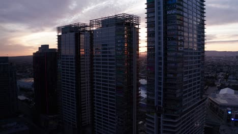 Rising-and-panning-aerial-shot-of-the-Oceanwide-Plaza-graffiti-skyscrapers-at-sunset-in-downtown-Los-Angeles,-California