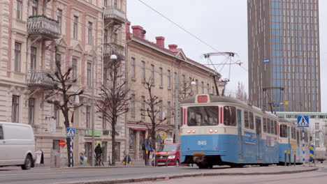 Dynamische-Göteborger-Winterstraßenszene-Mit-Fußgängern,-Autos-Und-Vorbeifahrender-Straßenbahn