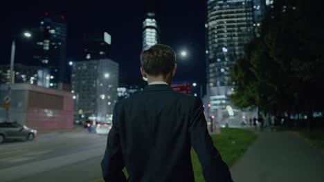 Following-shot-of-a-man-in-suit-walking-outside-office-building-while-returning-home-during-evening-time