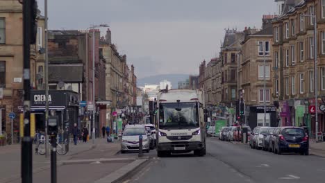 A-lively-Victoria-Road-with-a-rubbish-truck-pulling-up-to-frame