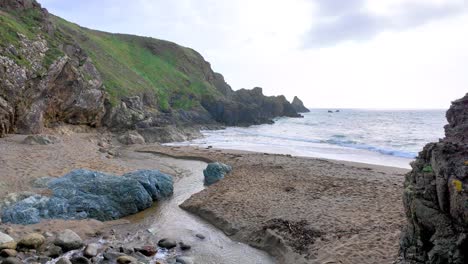 Arroyo-Que-Fluye-Hacia-La-Costa-De-La-Playa-De-Arena-De-Waterford,-Irlanda,-En-Una-Brillante-Mañana-De-Primavera