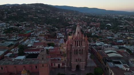 Drone-Elevándose-Sobre-La-Catedral-De-La-Parroquia-En-El-Centro-De-La-Ciudad-De-San-Miguel-De-Allende-Al-Amanecer-En-México