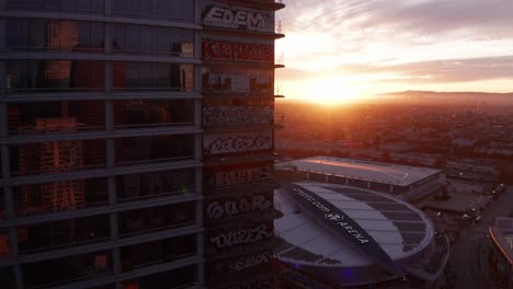 Slow-rising-and-panning-aerial-shot-of-the-Oceanwide-Plaza-graffiti-towers-at-sunset-in-downtown-Los-Angeles,-California