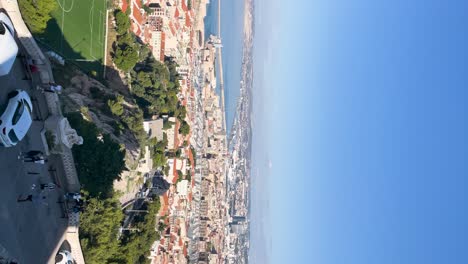 Wide-overview-pan-of-sunny-Marseille-port-area-from-hill,-vertical