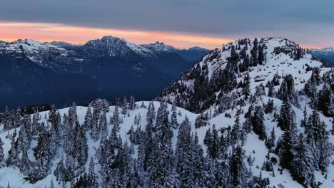 Paisaje-Escénico-De-Montañas-Y-árboles-Nevados,-Colorido-Cielo-Al-Atardecer