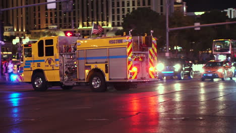 Las-Vegas,-EE.UU.,-Camión-Del-Departamento-De-Bomberos-Del-Condado-De-Clark-Con-Luces-De-Emergencia-Pasando-Por-La-Franja-Nocturna,-Cámara-Lenta