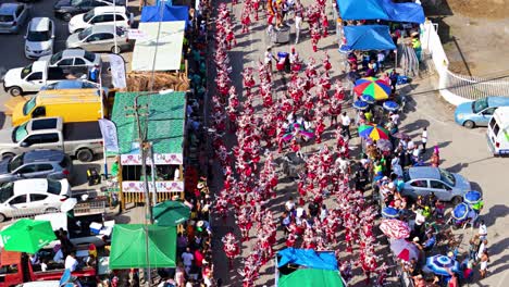 Drone-orbits-around-crowd-of-Carnaval-performers-dancing-in-streets-of-Curacao