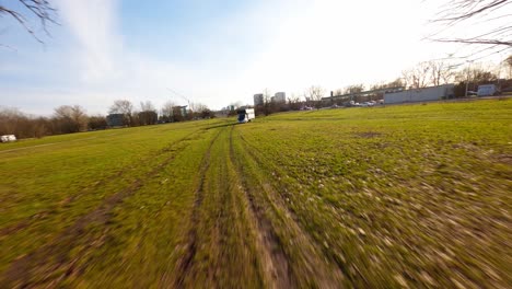 Sonnige-FPV-Luftaufnahme-Eines-Wohnmobils-Mit-Sonnenkollektoren-Auf-Freiem-Feld