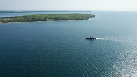 Drone-shot-revealing-a-large-charter-boat-with-people-and-cars-in-door-county