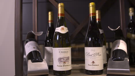 Wine-bottles-from-Pierre-Ponnelle-showcased-in-store,-red-wine-in-cupboard