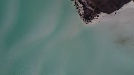 Turquoise-waters-of-Playa-Balandra,-Baja-California-with-rocky-shore,-aerial-view
