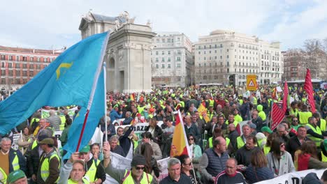 Schwenkaufnahme-Von-Spanischen-Landwirten-Und-Landwirtschaftsgewerkschaften,-Die-Die-Straßen-Blockieren,-Als-Sie-Sich-An-Der-Puerta-De-Alcalá-In-Madrid-Versammeln,-Um-Gegen-Unlauteren-Wettbewerb,-Landwirtschaft-Und-Regierungspolitik-Zu-Protestieren