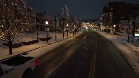 Snow-plow-driving-on-snowy-main-street-in-small-town-USA-during-white-Christmas