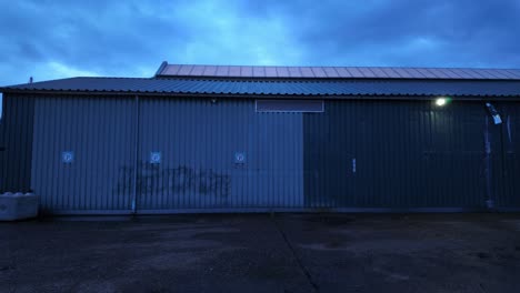 Wall-with-no-parking-signs-and-traces-of-graffiti-on-metal-wall-building-backyard