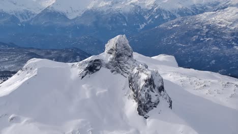 Riesige-Felsformation-Auf-Schneeweißem-Berggipfel-Aus-Der-Luft