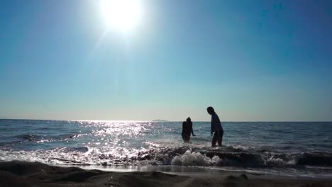 Zwei-Frauen-Am-Strand-Und-Die-Andere-Spritzwasser-Zu-Ihrer-Freundin