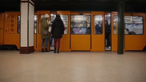 People-taking-metro-line-M1-in-Budapest,-using-public-transport-in-Hungary,-the-oldest-Hungarian-subway-line,-tube-station,-Millennium-Underground-Railway,-first-underground-on-the-European-mainland