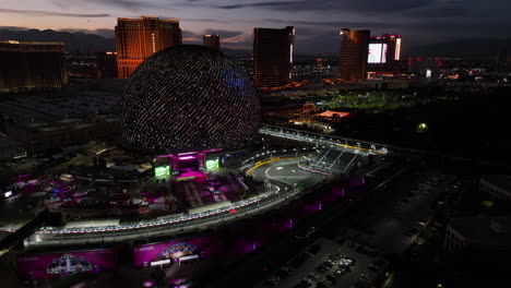 Drone-rotating-toward-a-stage-at-the-Sphere,-during-a-Las-Vegas-Formula-evening
