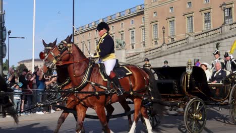 King-and-Queen-of-Sweden-in-horse-drawn-carriage-on-National-Day,-slow