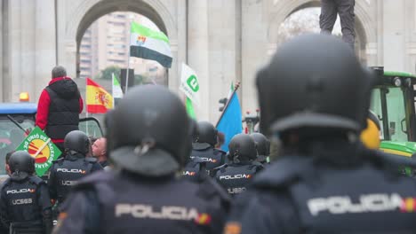 Polizisten-Stehen-Wache,-Als-Sich-Spanische-Landwirte-Und-Agrargewerkschaften-Auf-Der-Plaza-De-La-Independencia-Versammeln,-Um-Gegen-Unlauteren-Wettbewerb,-Agrar--Und-Regierungspolitik-Zu-Protestieren