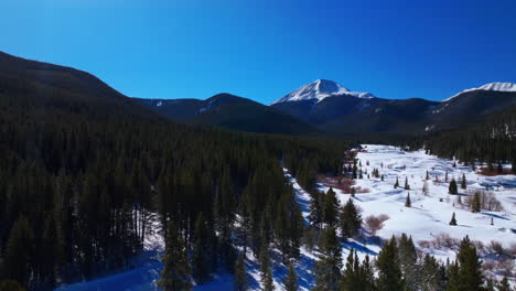 Snowmobile-dog-sled-trail-track-Boreas-Mountain-Pass-Breckenridge-Colorado-aerial-drone-cinematic-Backcountry-blue-clear-sky-North-Fork-Tiger-Road-Bald-Rocky-Mountains-winter-fresh-snow-upward-motion