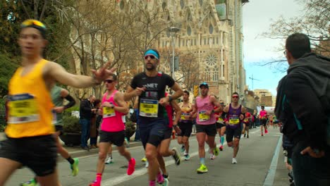 Runner-Embraces-race-with-Open-Arms-Barcelona-Marathon-2024-near-Sagrada-Familia-in-slow-moiton