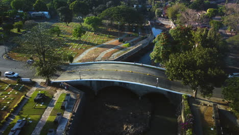 Vista-Aérea-Sobre-El-Tráfico-Y-La-Gente-En-Un-Puente-En-El-Parque-Conmemorativo-De-Manila,-Filipinas