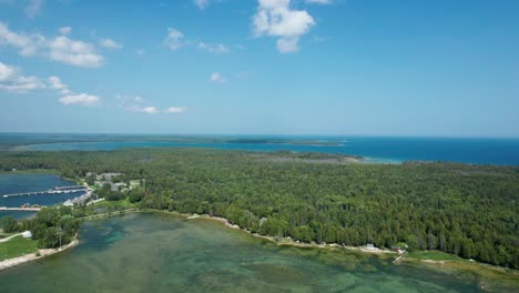 Drone-view-overlooking-forest-and-shoreline-of-lake-Michigan-in-door-county