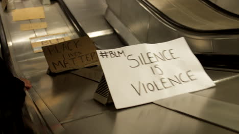 Powerful-signs-from-BLACK-LIVES-MATTER-protest-London-displayed-on-escalator-in-London-underground