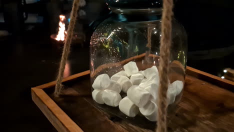 White-marshmallows-inside-large-glass-jar,-ready-to-roast-over-campfire