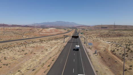 Vista-Aérea-Del-Tráfico-En-La-Autopista-De-Veteranos-En-El-Paisaje-Desértico-De-Utah,-EE.UU.