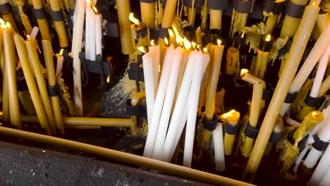 Lighting-and-burning-candles-as-prayer-and-promise,-Fatima,-Portugal