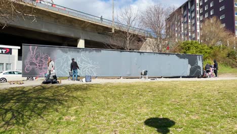 Männer-Bereiten-Kunstwerke-An-Einer-Legalen-Graffitiwand-Im-Sonnenlicht-In-Stockholm-Vor