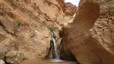 Waterfall-cascading-through-a-desert-canyon-in-Tozeur,-Tunisia,-serene-and-isolated