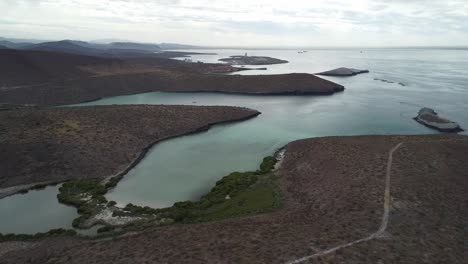 Baja-california's-playa-balandra,-with-serene-waters-and-rugged-coastline-at-dusk,-aerial-view