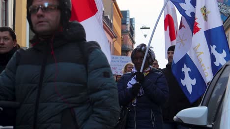 Woman-with-Christian-flag-walks-in-covid-vaccine-protest-march,-slomo