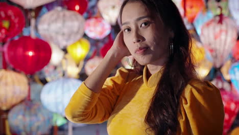 Mujer-Vestida-De-Amarillo-Ao-Dai-Admira-Coloridas-Linternas-En-Hoi-An-Por-La-Noche