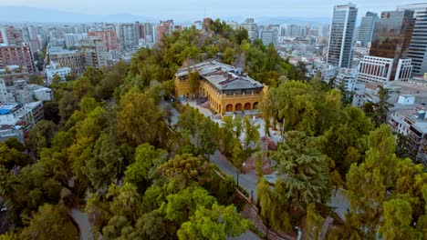 Aerial-Drone-Flying-Towards-Yellow-Cultural-Building-Castle-On-Santa-Lucia-Hill,-Santiago-Chile-Chiloe-4K