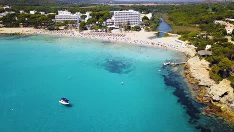 Drone-approaching-slowly-towards-the-beachfront-of-Playa-de-Canyamel,-a-paradise-getaway-located-in-the-Mediterranean-island-of-Mallorca-in-Spain