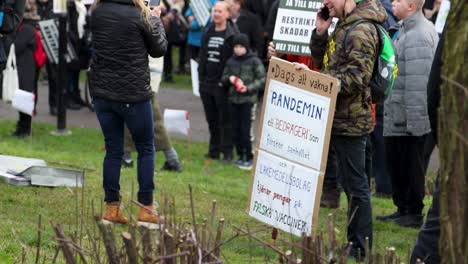 People-with-signs-protesting-Covid-regulations-in-park-in-Sweden