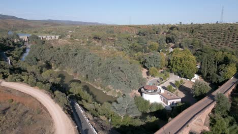 Vista-Aérea-Del-Puente-Del-Siglo-XVI-Sobre-El-Río-Guadalquivir,-Junto-A-Jardines-Y-árboles-Del-Balneario.