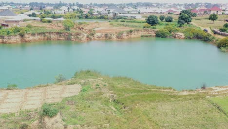A-lake-formed-by-a-natural-dam-near-Jos,-Nigeria---aerial-orbit-parallax