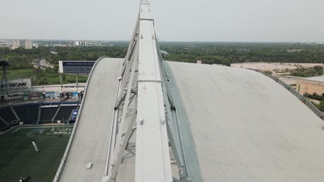 Luftdrohne-Mit-Grauem-Metallgerüstdach-Auf-Einem-Riesigen-Sportstadion