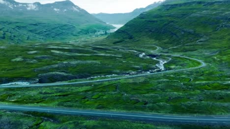 A-4K-drone-captures-cinematic-aerial-footage,-offering-distinctive-perspectives-of-a-winding-road-amidst-Iceland's-mountainous-landscape