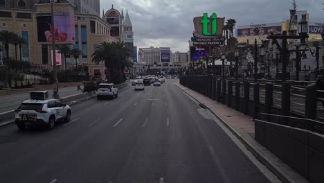 Driving-on-Las-Vegas-Strip-at-Twilight,-Cars-Passing-by-Hotels-and-Casinos,-Driver's-POV