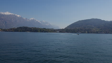 Boat-Cruising-On-Lake-Como-With-Mountains-In-Background-In-Bellagio,-Italy